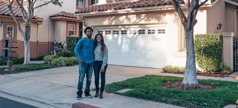 a couple standing in front of their home