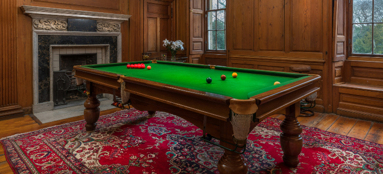 Spacious attic room with a pool table under skylights, a TV, and sitting area.