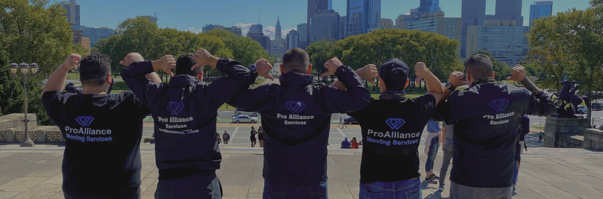 Pro Alliance Services crew with their backs to the camera, wearing branded company jackets