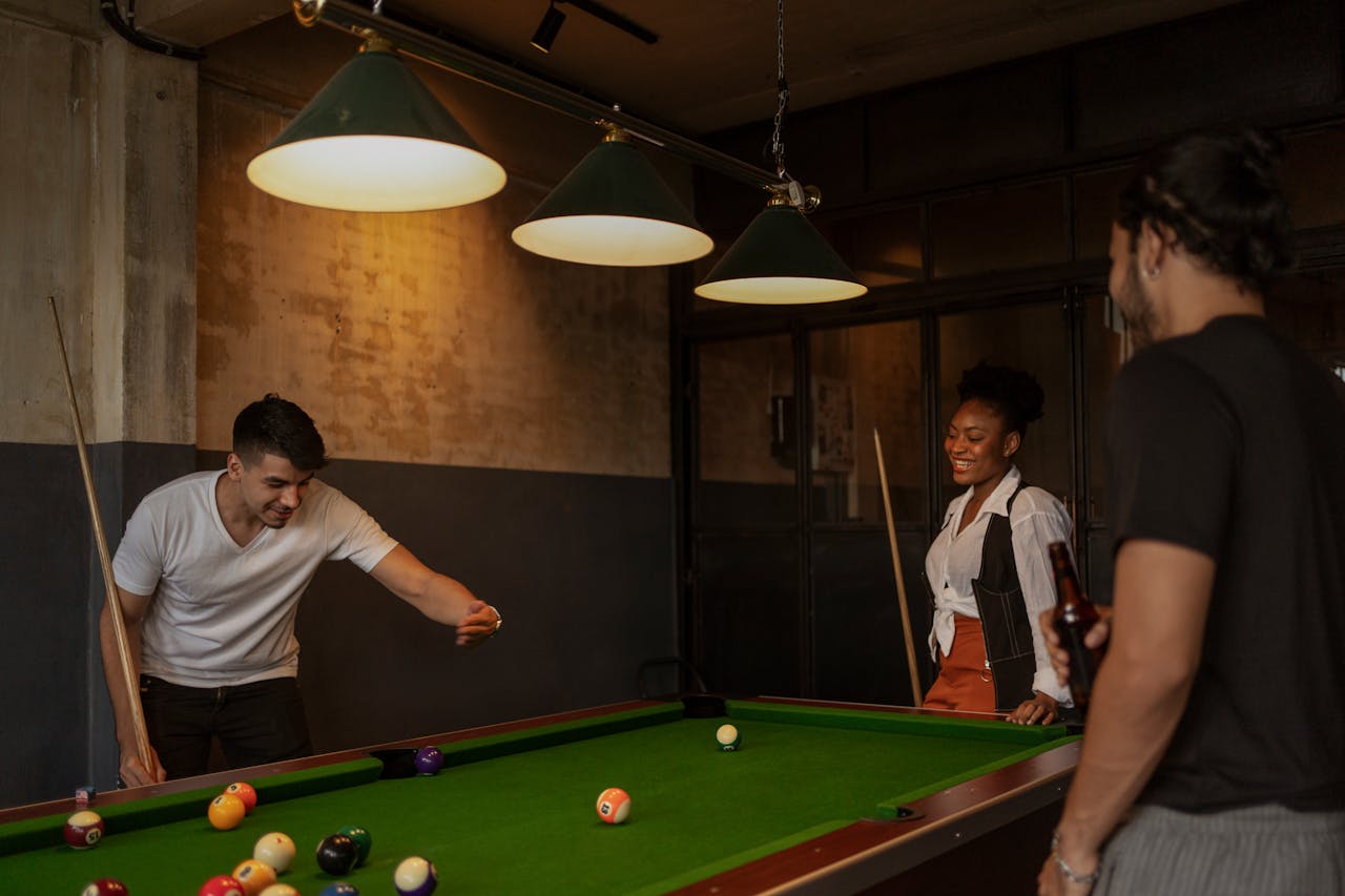 Friends around pool table discussing about pool table maintenance tips after relocating