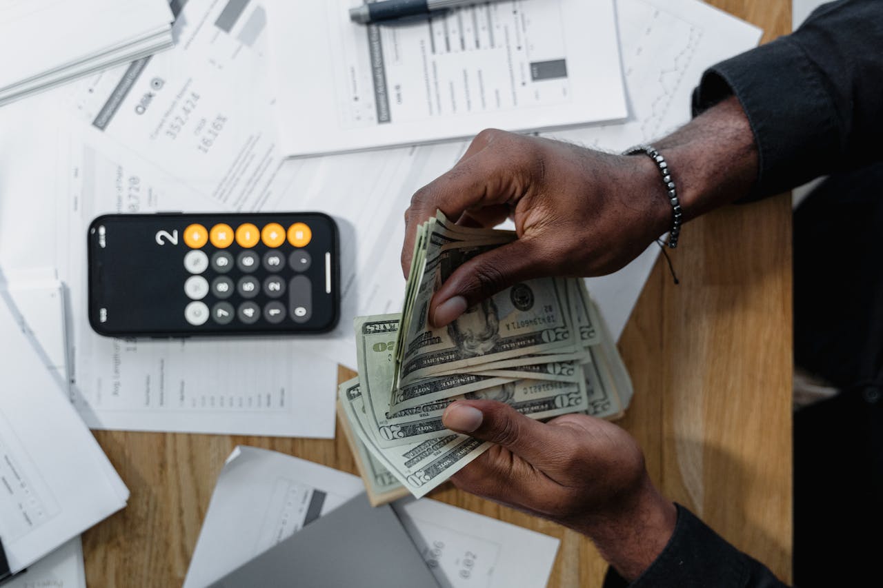 A person calculating dollar bills