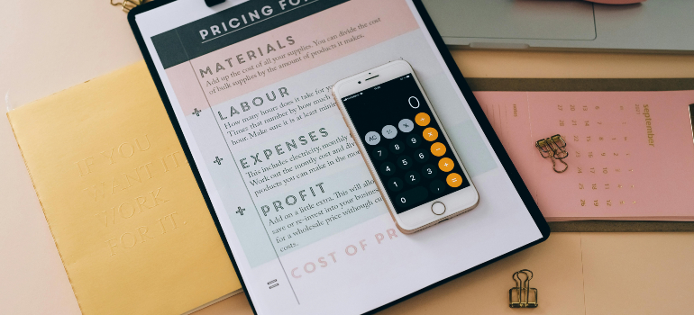 Moving cost breakdown and calculator on clipboard, showing how pricing ties into questions to ask before hiring a moving company.