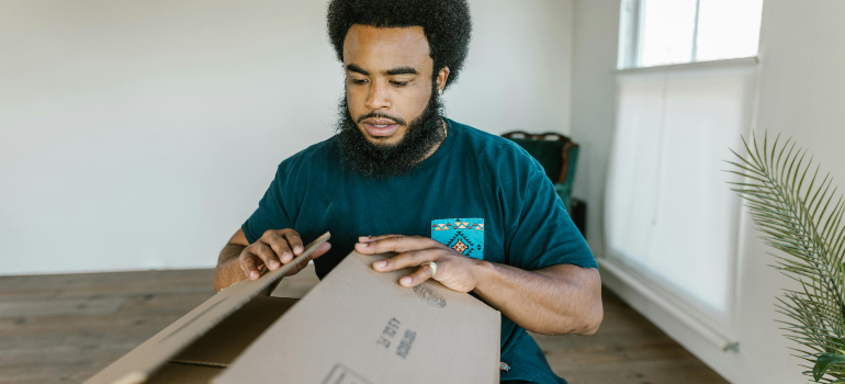 A mover closing a packing box.