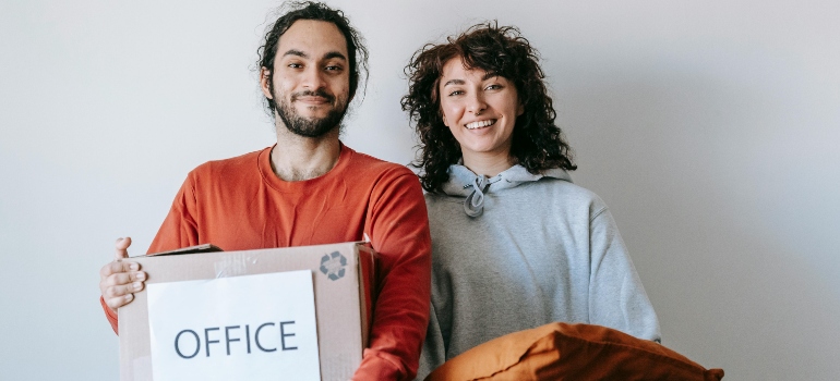 Happy movers holding boxes, while the one labeled 'OFFICE' screams a reminder: Protect Office Documents During a Move.