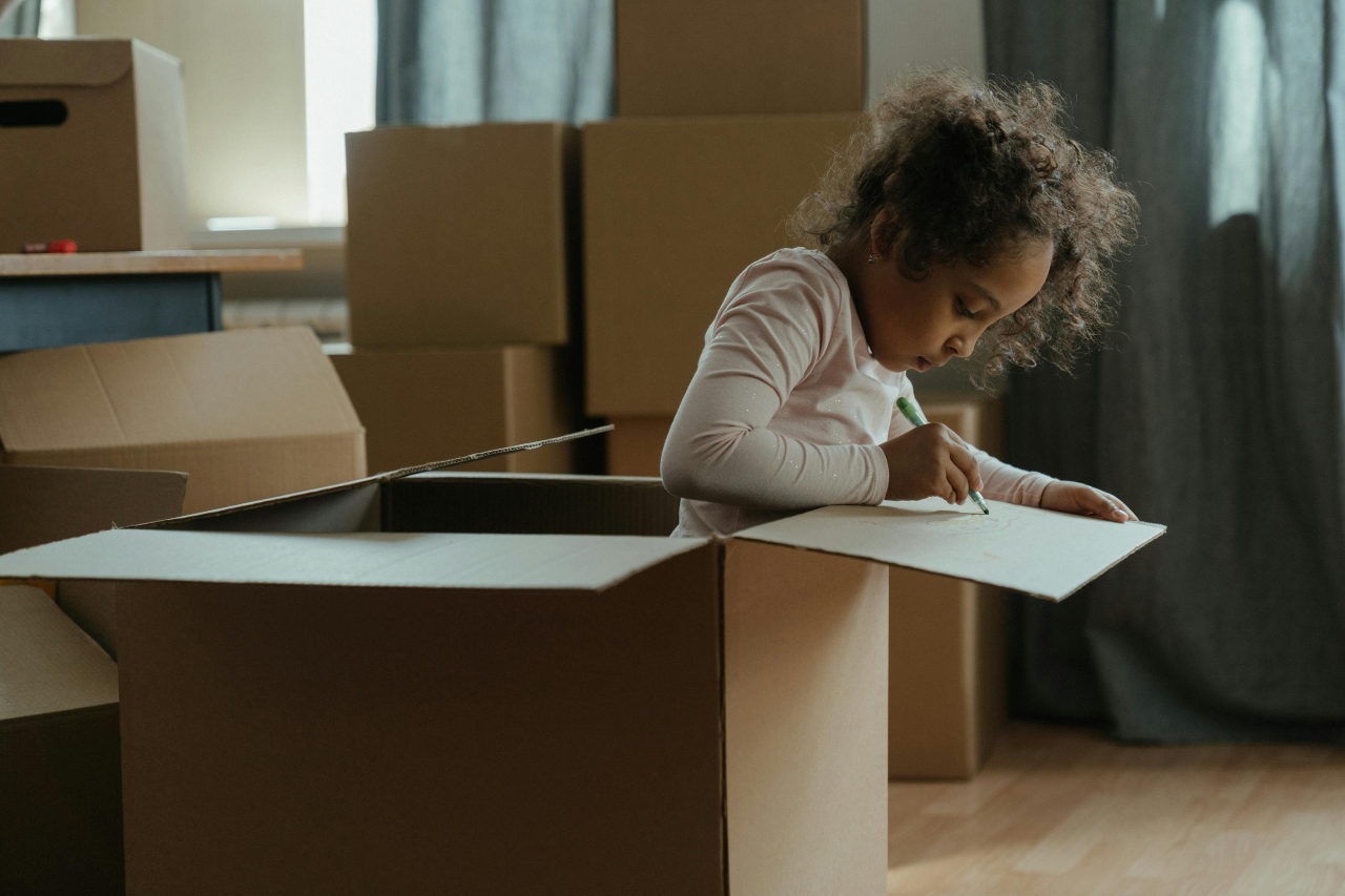 Girl in Pink and White Striped Long Sleeve Shirt Writing on the box